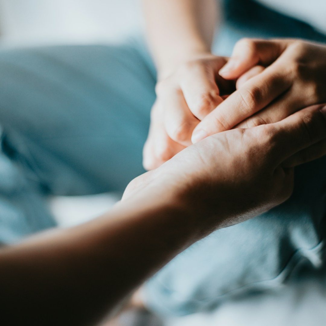 Two people holding hands as a symbol of compassionate funeral support on the Isle of Wight