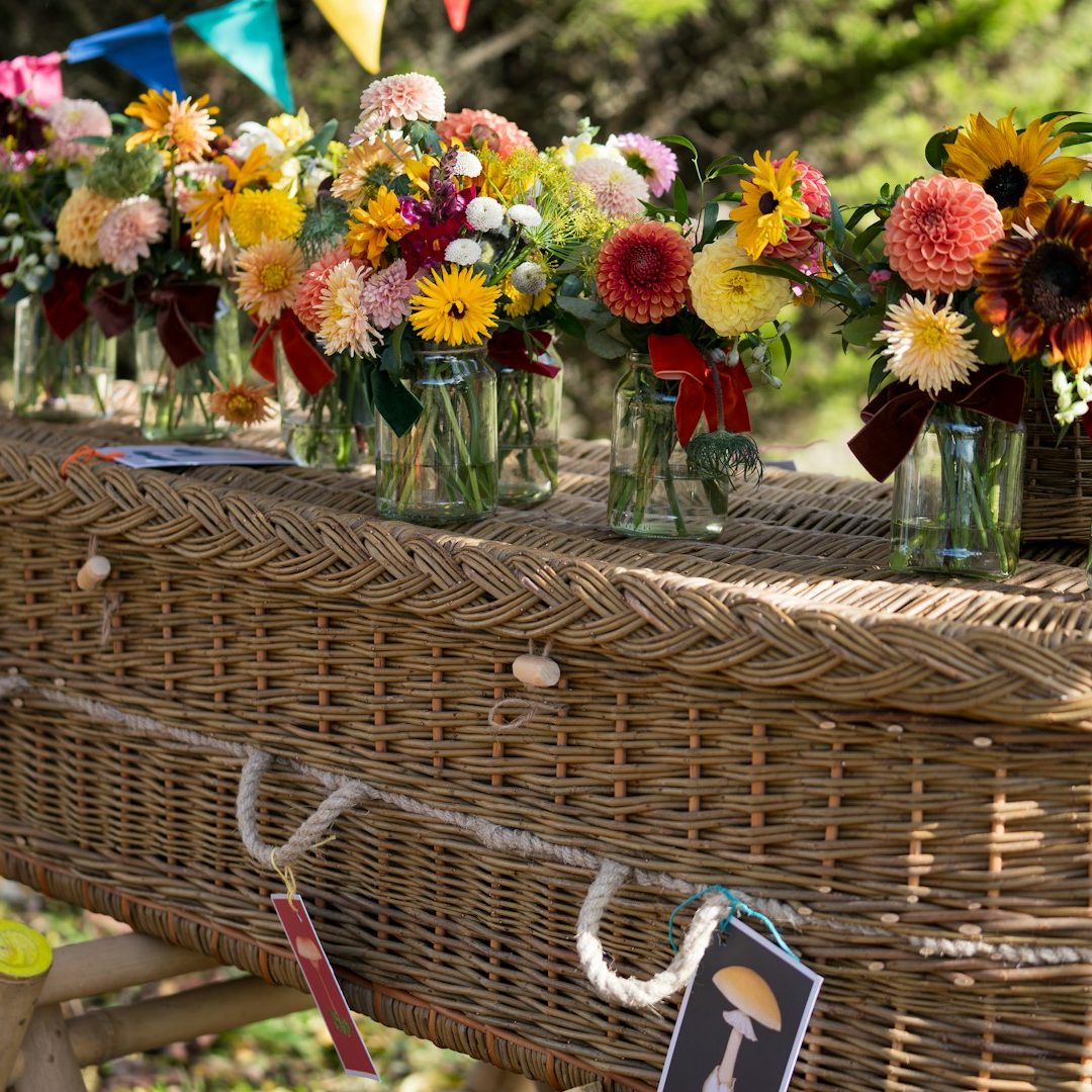 Wicker coffin decorated with flowers for a simple cremations on the Isle of Wight by Life Funerals